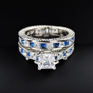 Detail of square zircon ring set with blue and white stones on black background
