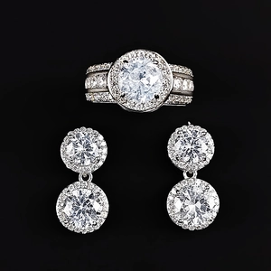 Classic silver jewelry set featuring halo round cut crystal ring and matching earrings