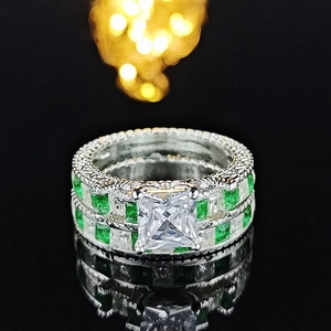 Luxurious silver ring stack featuring princess cut stone and green square emerald stones