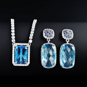 Luxurious silver jewelry set with light blue rectangular gemstones and tennis necklace