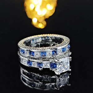 Macro view of bridal ring set with princess-cut center stone and blue channel-set gems