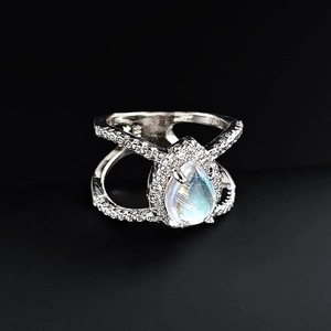 Detailed close-up of a pear-cut moonstone ring with a silver double-cross band design