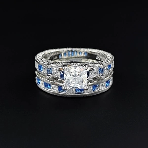 Detail of luxury square zircon rings with blue accent stones on a black background