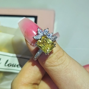 Macro view of rectangular yellow gemstone ring with marquise diamonds and pavé setting