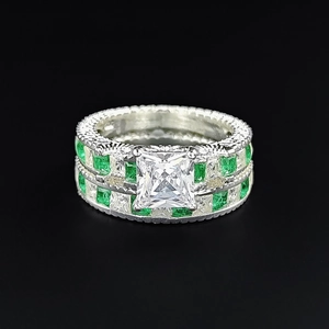 Macro shot of silver stacking rings with green zircon stones and milgrain texture