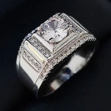 Dettaglio macro di anello largo in argento con pietra centrale tonda e pavé di diamanti