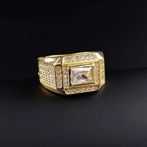 Macro shot of men's iced out gold ring with rectangular zircon and pave diamond details