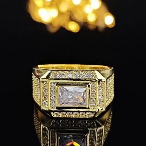 Macro shot of gold ring featuring a rectangular zircon centerpiece and micro-pave stones