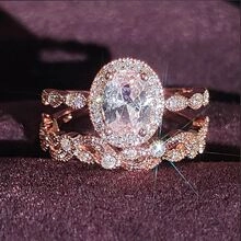 Macro shot of rose gold halo ring set with oval clear stone on purple velvet