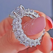 Detailed close-up of a large sapphire-style sparkling diamond ring on a hand