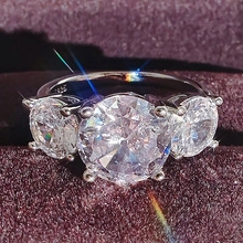 Close-up of three-stone S925 silver wedding ring with sparkling zircons and six-prong setting
