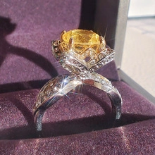 Macro shot of silver ring with yellow gemstone and diamonds in a purple velvet box