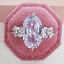 Macro detail of silver ring with oval cut gemstone in pink velvet hexagonal jewelry box