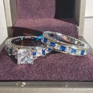 Elegant square-cut white and blue sapphire ring set displayed in a purple velvet jewelry box