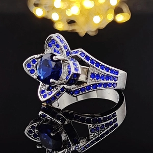 Macro shot of silver ring featuring star-shaped sapphire setting and blue zircon pavé detail