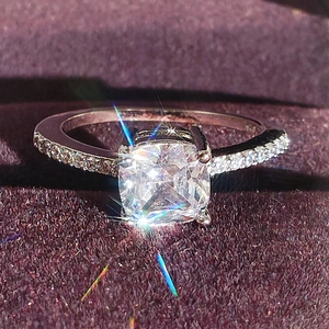 Classic cushion cut engagement ring with pavé diamond band in purple velvet box