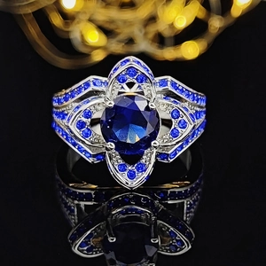 Luxurious silver ring featuring a large deep blue round zircon and floral pave setting