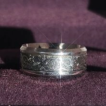 Close-up of titanium steel dragon ring with Celtic pattern on purple velvet background