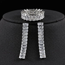 Macro view of silver jewelry set featuring emerald-cut cubic zirconia ring and drop earrings