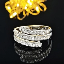Macro shot of silver triple-layer spiral ring with diamonds on black mirror surface