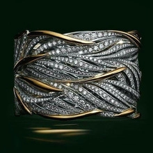 Macro detail of luxury men's ring with woven gold and pave-set silver zircon bands