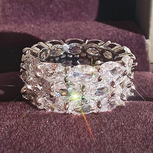 Luxe zilveren ring met drie rijen zirkonia steentjes op paars fluweel