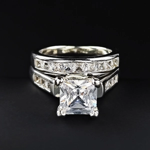 Elegantes Set aus Prinzess-Schliff Zirkonia Ringen mit silbernen Bändern auf Schwarz