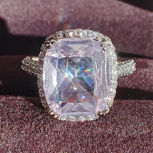 Classic halo ring with large cushion cut cubic zirconia on purple velvet background