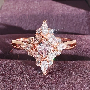 Elegant rose gold zircon ring with starburst geometric design in a velvet jewelry box