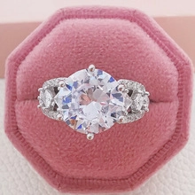 Macro detail of luxury silver ring with round zircon in a pink velvet jewelry box