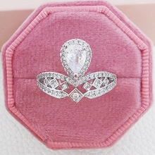 Macro shot of a luxury crown ring with a pear-shaped zircon in a pink velvet box