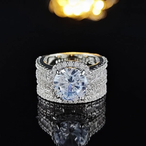 Dettaglio del set di anelli di lusso con halo di zirconi e riflesso su specchio nero lucido