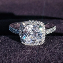 Makroaufnahme von Halo-Ring mit Zirkonia-Besatz und Pavé-Fassung in einer Geschenkbox