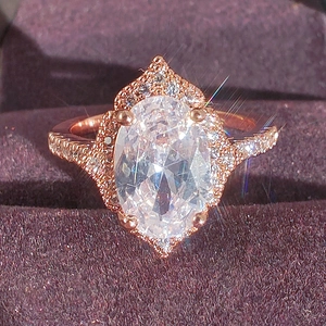Rose gold plated oval zircon halo ring featuring vintage crown setting on purple velvet
