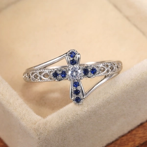 Cross ring with hollow pattern and micro-set blue zircon stones in silver finish