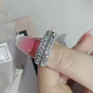 Anello largo placcato platino con file multiple di zirconi cubici indossato al dito