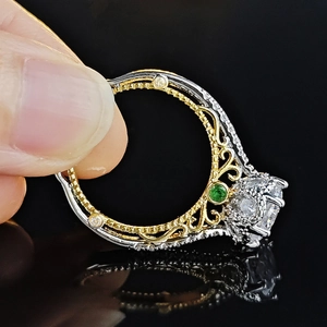 Zweifarbiger Ring aus Silber und Gold mit großem klarem Hauptstein und smaragdgrünem Akzent