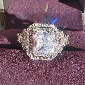 Classic rectangle cut zircon ring in rose gold with halo stones on velvet box