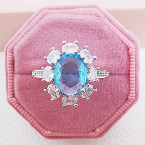 Silver flower ring with oval aquamarine stone and halo diamonds in pink velvet box