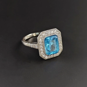 Eleganter Silberring mit rechteckigem meerblauem Stein und Mikrozirkon-Halo-Ring