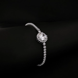 Elegante zilveren tennisarmband met een centrale ronde halo-diamant en glinsterende ketting