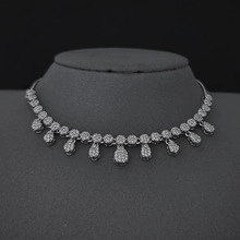 Detailed view of silver-tone teardrop pendant necklace with sparkling crystal inlay on bust
