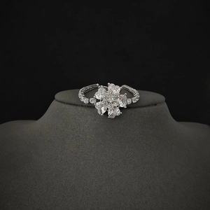 Elegant silver flower ring with clover shaped zircon gemstones on black display stand
