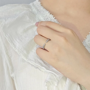 Minimalist silver open ring with pavé crystals on a model's hand with white blouse