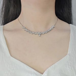Elegant silver bow necklace with water-drop diamond elements worn on a model