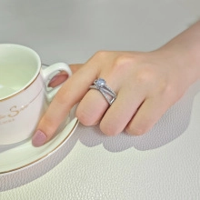 Detalle de anillo de compromiso cruzado de lujo con diamante brillante en el dedo