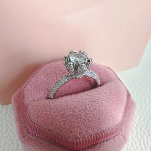 Elegant water drop petal ring with a round center stone in a pink velvet jewelry box