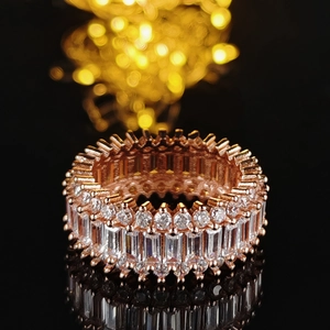 Makroaufnahme: Roségold-Ring mit Baguette- und Rundschliff-Steinen in Pavé-Fassung