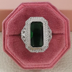 Anello vintage con smeraldo verde e cristalli bianchi in una scatola di velluto rosa