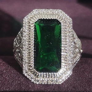 Anello vintage con gemma verde taglio smeraldo e doppio halo su fascia argentata
